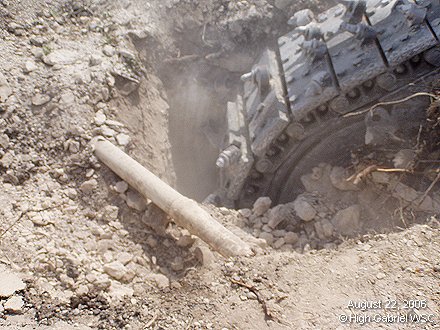 Trencher cuts under the existing water line